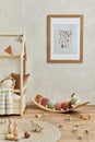 Stylish composition of cozy scandi child`s room interior with mock up poster frame, bed, plush caterpillar on balance board, toys. Royalty Free Stock Photo