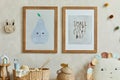 Stylish composition of cozy scandi child`s room interior with two mock up poster frames, rattan basket, toys and textile.