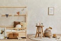 Stylish composition of cozy scandinavian child`s room interior with wooden bed, toys and hanging decorations. Creative wall. Copy.