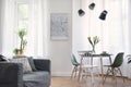 Stylish composition of creative dining room interior in scandinavian apartment with mock up map frame, table, chairs, sofa, shelf. Royalty Free Stock Photo