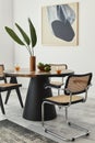 Stylish composition of dining room interior with design table, modern chairs, decoration, tropical leaf in vase, fruits, abstract. Royalty Free Stock Photo