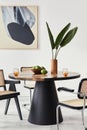 Stylish composition of dining room interior with design table, modern chairs, decoration, tropical leaf in vase, fruits, abstract. Royalty Free Stock Photo