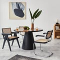 Stylish composition of dining room interior with design table, modern chairs, decoration, tropical leaf in vase, fruits. Royalty Free Stock Photo