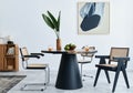 Stylish composition of dining room interior with design table, modern chairs, decoration, tropical leaf in vase, fruits. Royalty Free Stock Photo