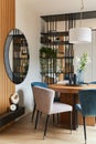 Stylish composition of elegant dining room interior design with velvet armchairs, design rounded wooden table and beautiful. Royalty Free Stock Photo