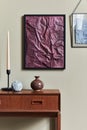 Stylish composition at living room with wooden retro commode, black mock up poster frame, candlestick, vase.