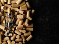 Stylish composition - a lot of wine corks and a corkscrew for wine. Isolated on black background. There is free space for Royalty Free Stock Photo