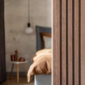 Stylish composition of modern bedroom interior. Bed, creative lamp and elegant personal accessories. Concrete wall. Brown sheeets