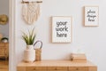 Stylish composition of modern hall interior with elements of rustic and boho style with two mock up poster frames, wooden commode. Royalty Free Stock Photo