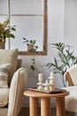 Stylish composition of modern living room interior details. Creative handmade candles on the wooden coffee table. Home staging. Royalty Free Stock Photo