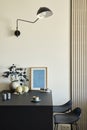 Stylish composition of modern small dining space interior. Black kitchen island and dining accessories. Neutral walls.