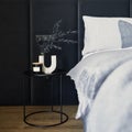 Stylish composition of small modern bedroom interior. Bed, creative lamp and elegant personal accessories.