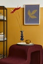 Stylish compositon in modern living room interior with design stool, vase with flower, bookcase and mock up poster frame. Yellow