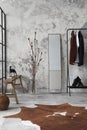 The stylish compostion at living room interior with concrete wall, hanger mirror, wooden bench and elegant personal accessories. Royalty Free Stock Photo