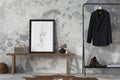 The stylish compostion at living room interior with mock up, concrete wall, bench, hanger with clothes and elegant personal Royalty Free Stock Photo