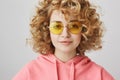 Stylish and cool partying girl. Portrait of relaxed fashionable woman with curly blond hair wearing trendy round Royalty Free Stock Photo