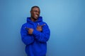 stylish cool young guy american with dark skin is dressed in a trendy sweatshirt with a hood on a studio background with Royalty Free Stock Photo