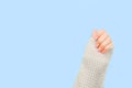 Stylish orange nails on blue knitted backdrop. Royalty Free Stock Photo