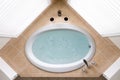 Stylish corner oval bathtub in a tile surround Royalty Free Stock Photo