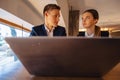 A stylish couple drinks morning coffee at the cafe and works with a laptop, young businessmen and freelancers Royalty Free Stock Photo