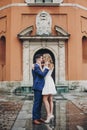 Stylish couple embracing together in european city street on background of old architecture. Fashionable man and woman in love Royalty Free Stock Photo