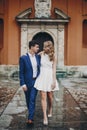 Stylish couple embracing together in european city street on background of old architecture. Fashionable man and woman in love Royalty Free Stock Photo