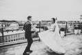 Stylish couple of happy newlyweds. Bride running from groom in the park on their wedding day with bouquet Royalty Free Stock Photo