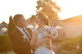 Stylish couple of happy newlyweds posing in the park on their wedding day. Perfect couple bride, groom funny joke Royalty Free Stock Photo