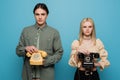 Stylish couple holding retro telephones isolated