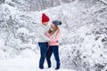 Stylish couple in knitted clothes during snowfall