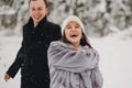 Stylish couple in love having fun in snowy mountains. Happy family playing in snow and smiling in winter mountains and forest. Ho Royalty Free Stock Photo
