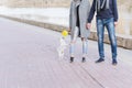 Stylish couple in love is walking with dog along the promenade