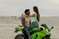 Stylish couple on motorbike on beach