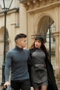 Stylish couple posing in motion at a wrought iron gate