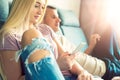 stylish couple sitting on a sofa relaxing at their modern home. Woman holding mobile phone, browsing the web