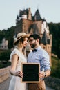 Stylish couple stand and kissing each other and hold the plate