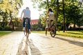 Stylish couple of young people ride in the park during the autumn season at sunset. Active cycling in the city on the weekend.