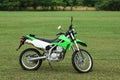 Stylish cross motorcycle on green grass outdoors