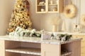 Stylish cuisine with decorated Christmas tree. Festive Xmas garland with lights, branches spruce and gift on wooden table.