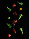 Stylish culinary composition. On a simple black background, a bright assortment of boiled crayfish, broccoli, cherry tomatoes in