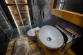 Stylish dark bathroom interior with shower. Tiles imitating wood on the floor and on the wall