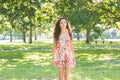 Stylish day dreaming brunette walking on grass