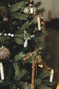 Stylish decorated christmas tree with vintage baubles, ribbons, candles and golden lights. Atmospheric winter holiday time. Royalty Free Stock Photo