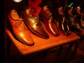 Elegant men`s leather shoes on display on small brown wooden table