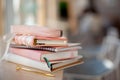 Stylish designed coral and white coloured stack of diaries with gold pen.