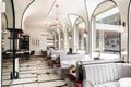 Stylish dining corner with gray velvet dining chair and luxury gold stainless chandelier hanging from the ceiling in natural light