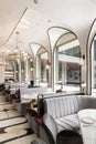 Stylish dining corner with gray velvet dining chair and luxury gold stainless chandelier hanging from the ceiling in natural light