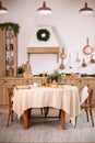 Stylish dining room in rustic style. Cozy Wooden kitchen decorated Christmas or new year. On table fir branche in vase, Xmas cooki Royalty Free Stock Photo