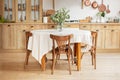 Stylish dining room with wooden retro furniture. Cozy cuisine decorated with summer decor. Kitchen utensils, dishes, plates. Inte