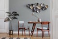 Stylish dining room with wooden table and vintage chairs.